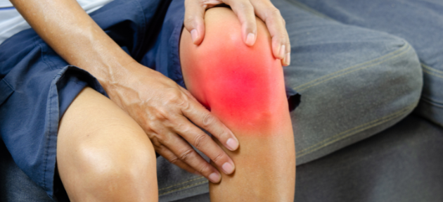 Close-up of a person gripping their knee in pain, representing common conditions like osteoarthritis and tendonitis treated with PRP therapy